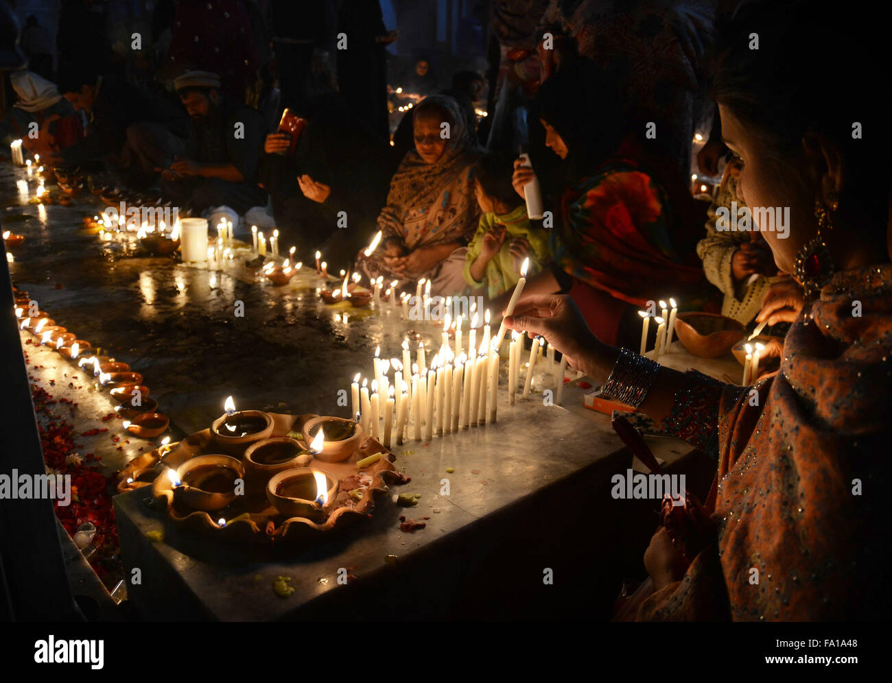 Lahore, Pakistan. 19th Dec, 2015. Pakistani Muslim devotees light