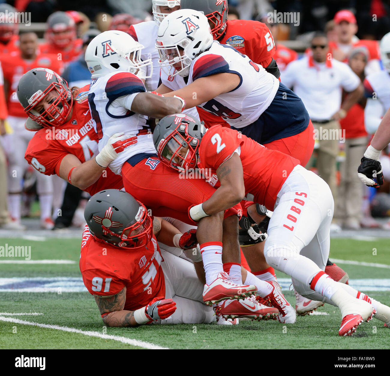 Albuquerque, New Mexico, USA. 19th Dec, 2015. New Mexico Lobos' DAKOTA COX, KIMMIE CARSON and NIK D'AVANZO stop Arizona Wilcats' JARED BAKER in the first half of NCAA Football action at Branch Field. © Jim Thompson/Albuquerque Journal/ZUMA Wire/Alamy Live News Stock Photo