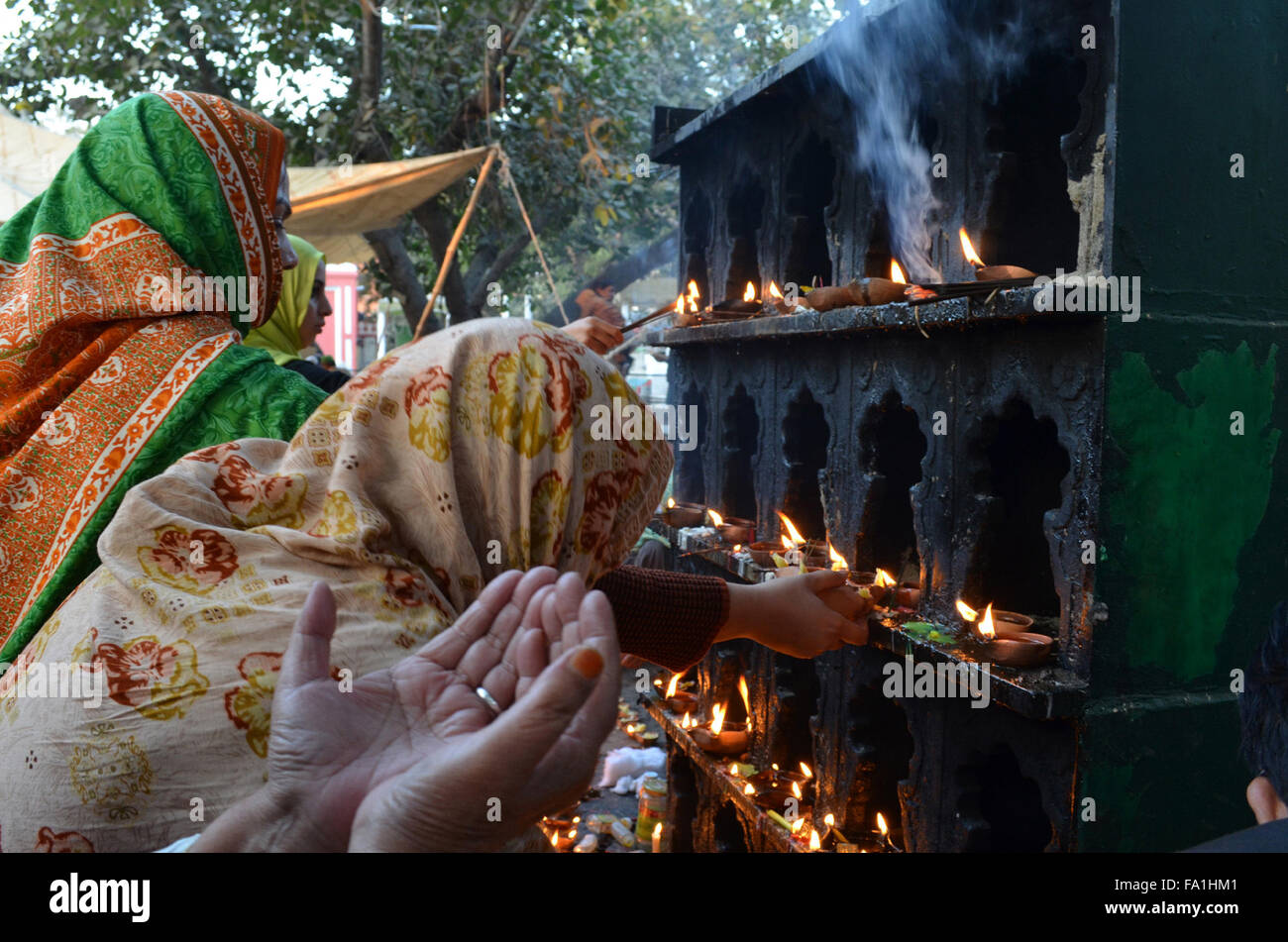 Lahore. 19th Dec, 2015. Pakistani Muslim devotees light candles and oil lamps at the shrine of the Sufi saint Mian Mir Sahib during a festival to mark the saint's death anniversary in eastern Pakistan's Lahore, Dec. 19, 2015. Hundreds of devotees are attending the two-day festival. © Jamil Ahmed/Xinhua/Alamy Live News Stock Photo