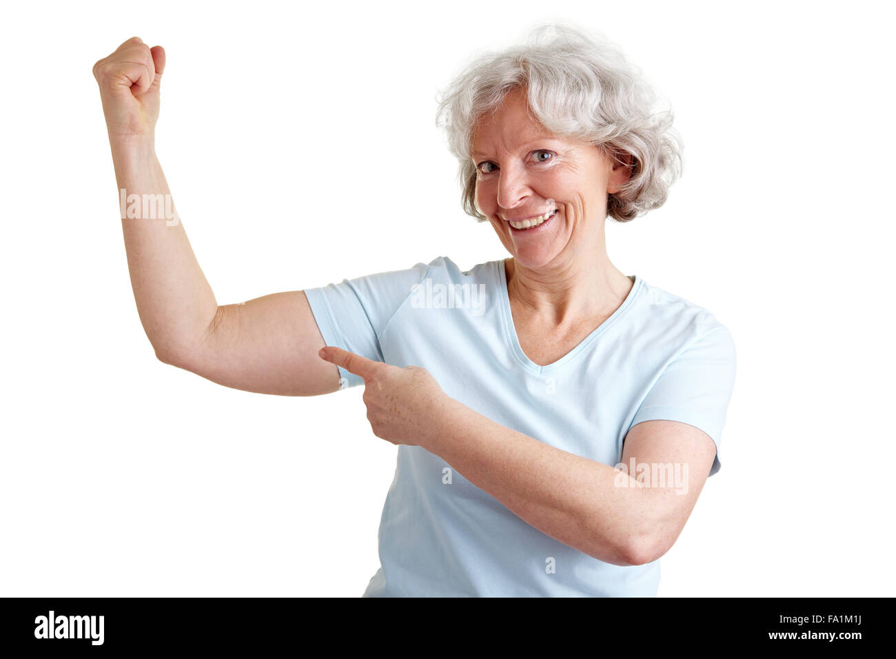Elderly happy senior woman doing fitness exercises and showing her muscles Stock Photo