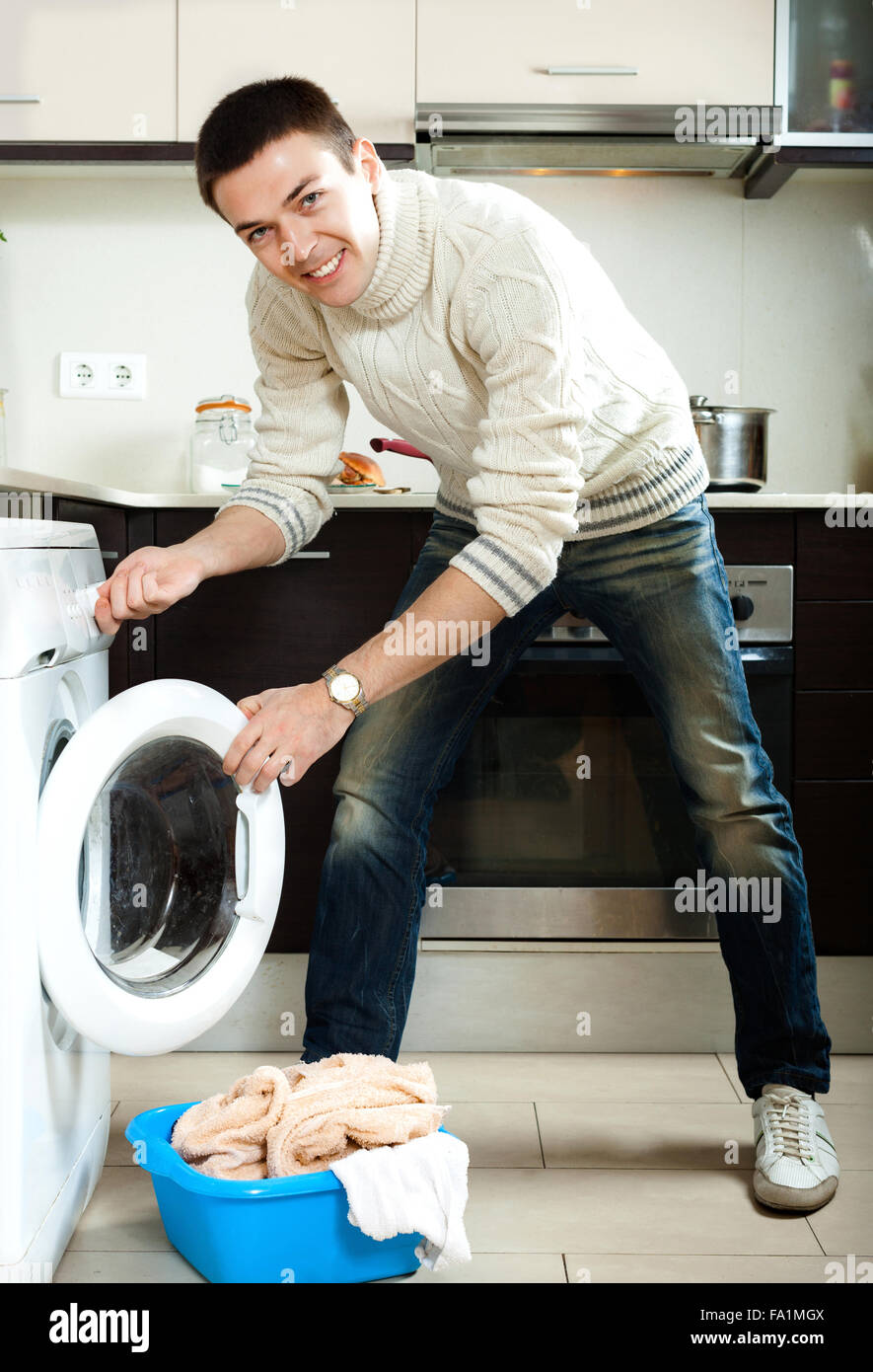 https://c8.alamy.com/comp/FA1MGX/home-laundry-handsome-guy-loading-clothes-into-the-washing-machine-FA1MGX.jpg