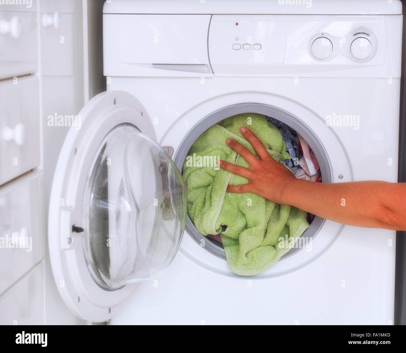 Woman loaded clothes into washing machine. Close up Stock Photo Alamy