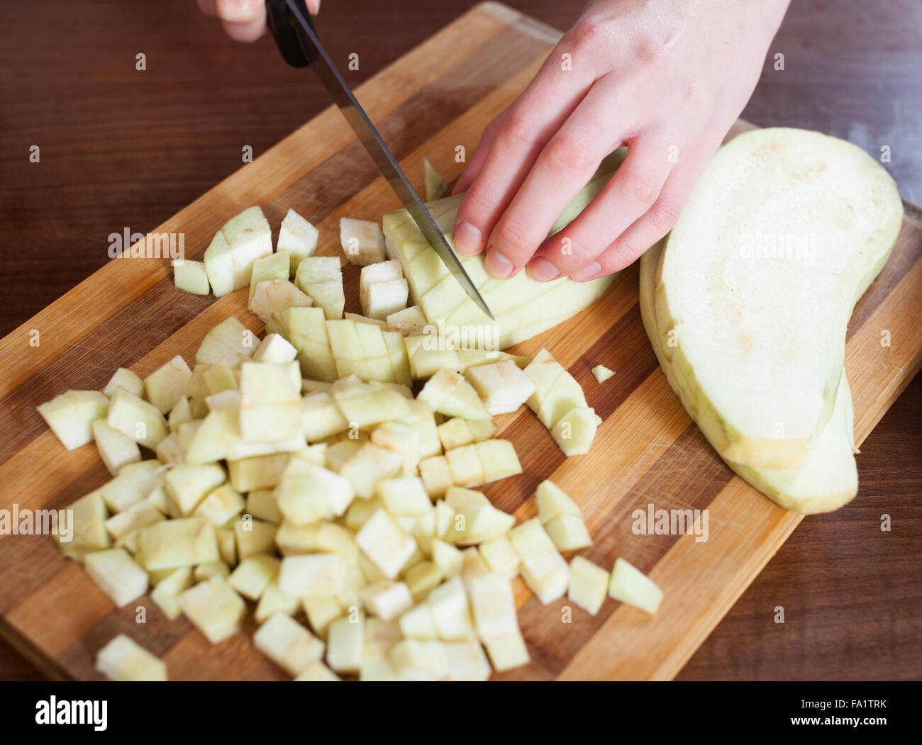 Close uo of female hands cutting the eggplant in home kitchen Stock Photo