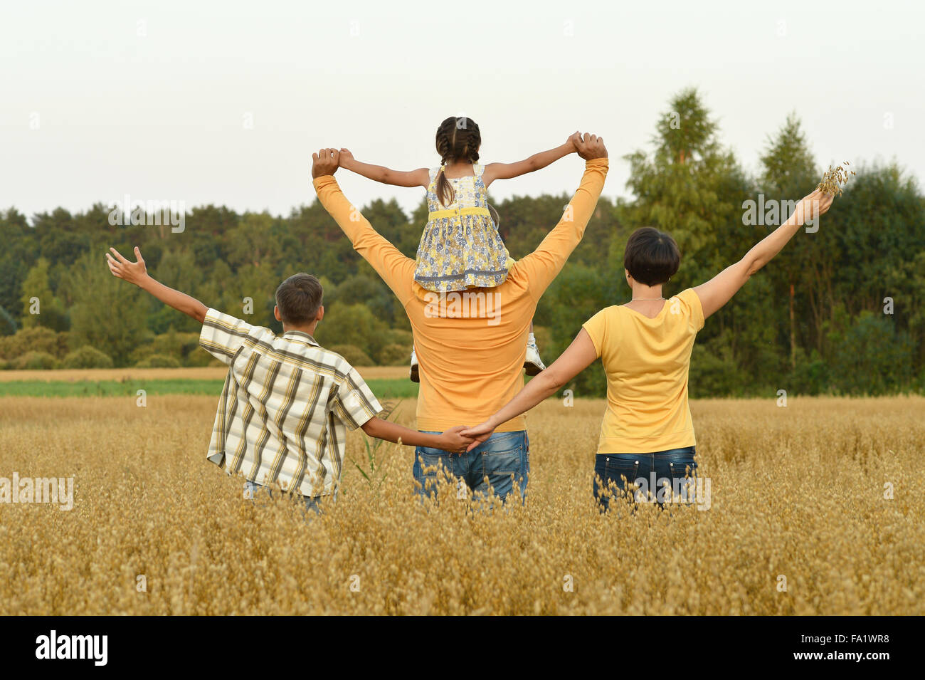 Happy family in wheat field Stock Photo - Alamy