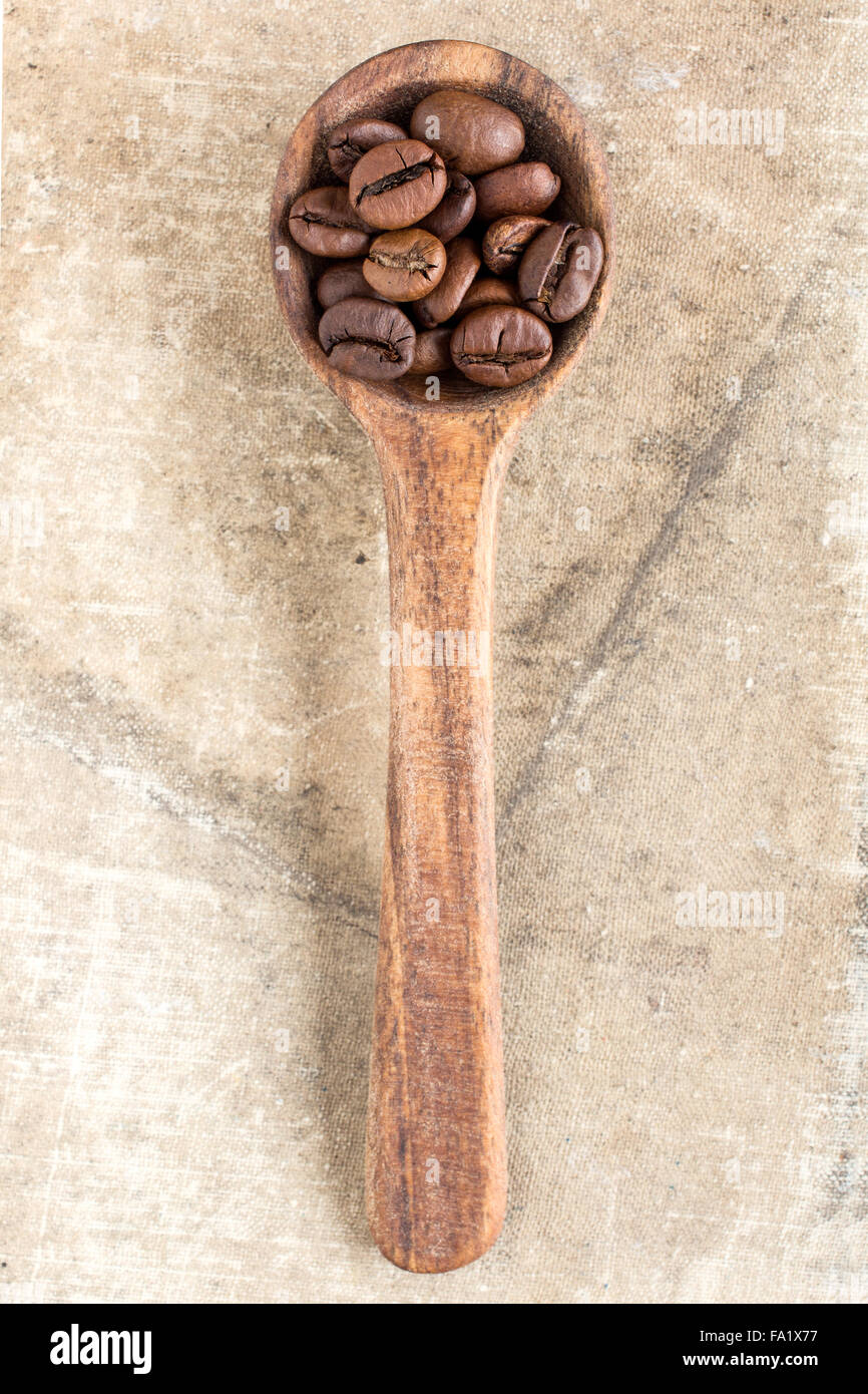 Spoon with coffee crop beans on canvas background Stock Photo