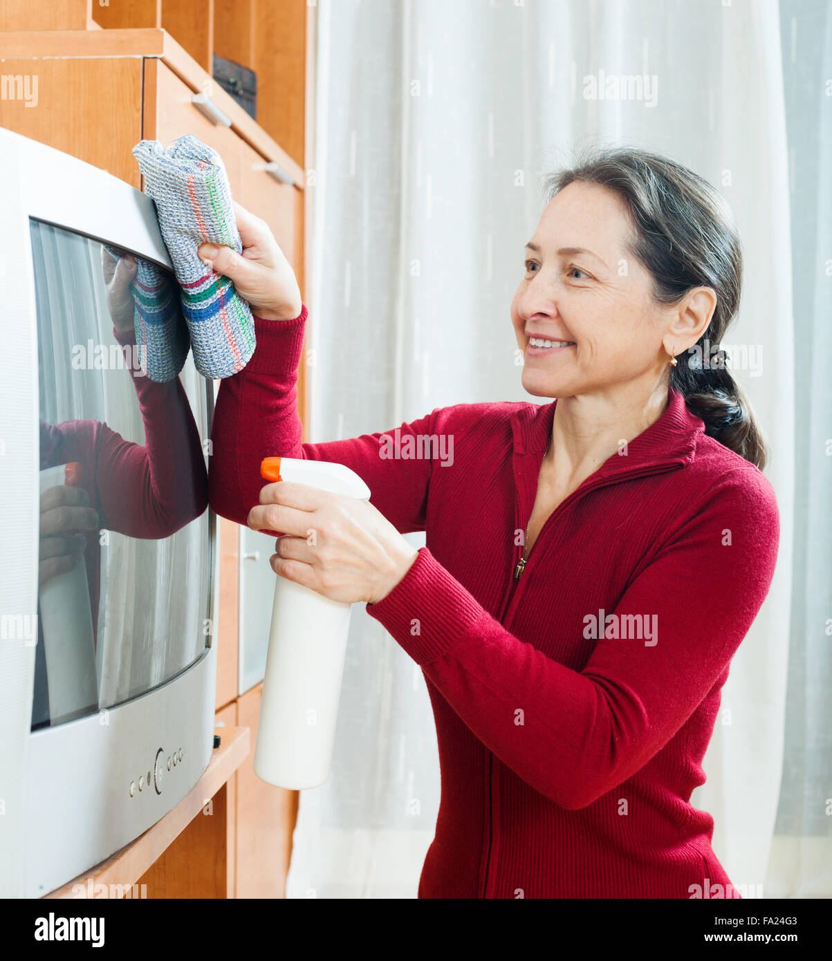 Ordinary mature woman cleaning tv hires stock photography and images
