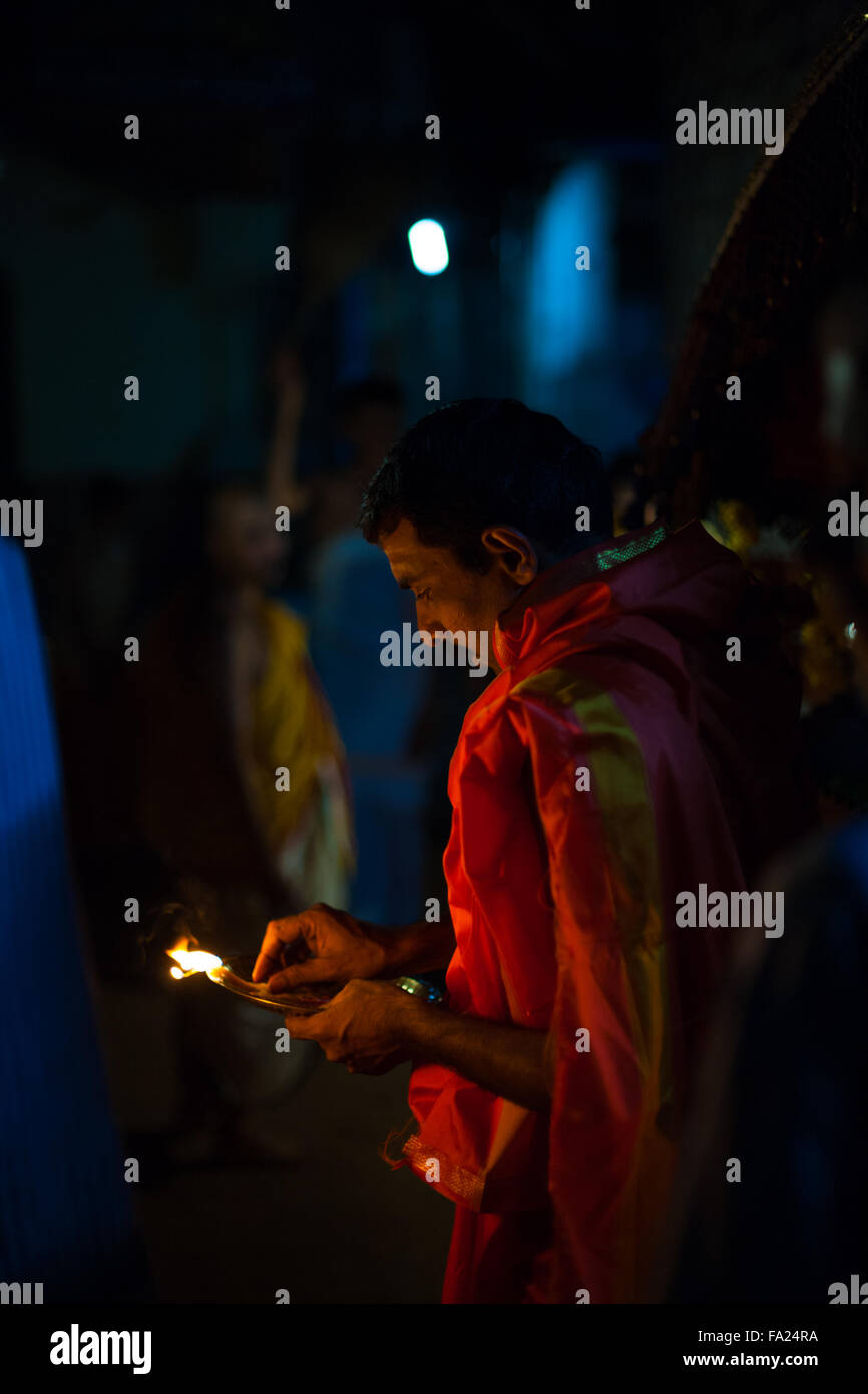 Indian brahmin priest blessing a house by burning incense at night during a monthly full moon hindu ceremony Stock Photo