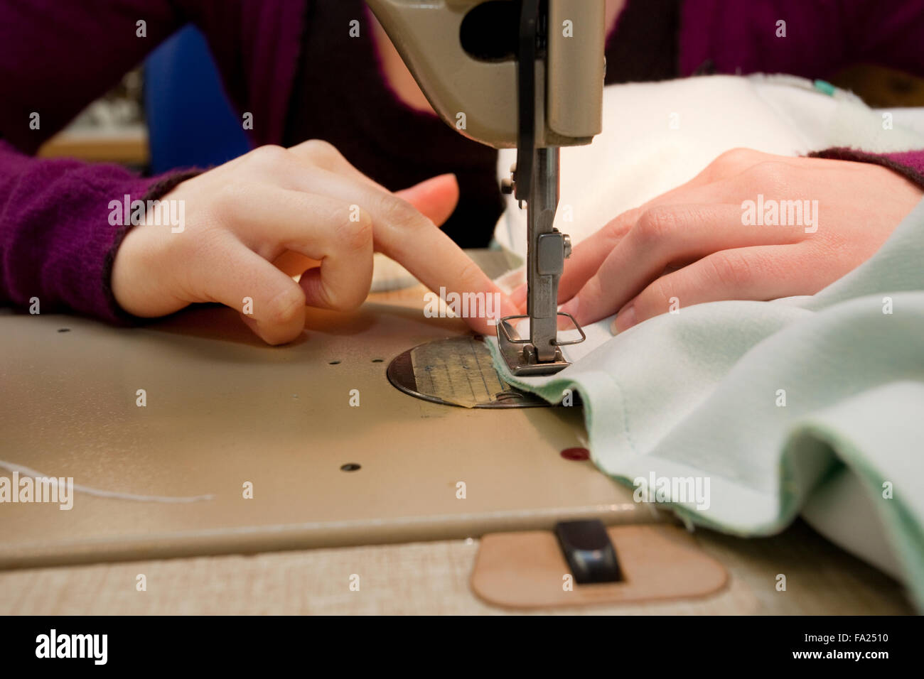 Custom tailor works at a sewing machine. Stock Photo