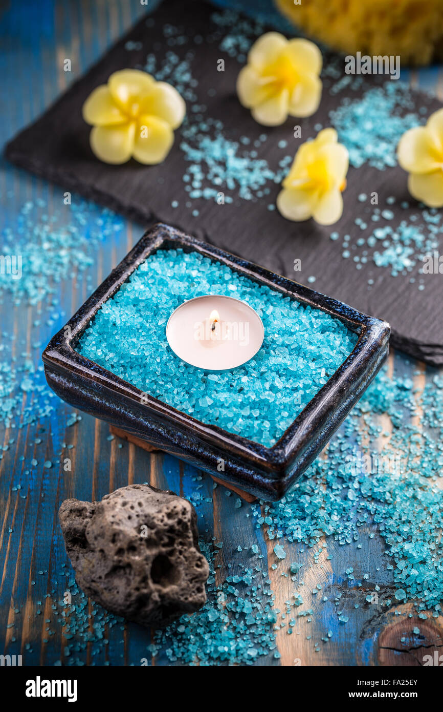 Tranquil spa relaxation setting, blue bath salt and candles Stock Photo