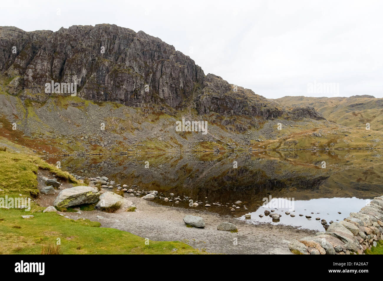 Pavey Ark reflected in Stickle Tarn one early Autumn morning Stock Photo