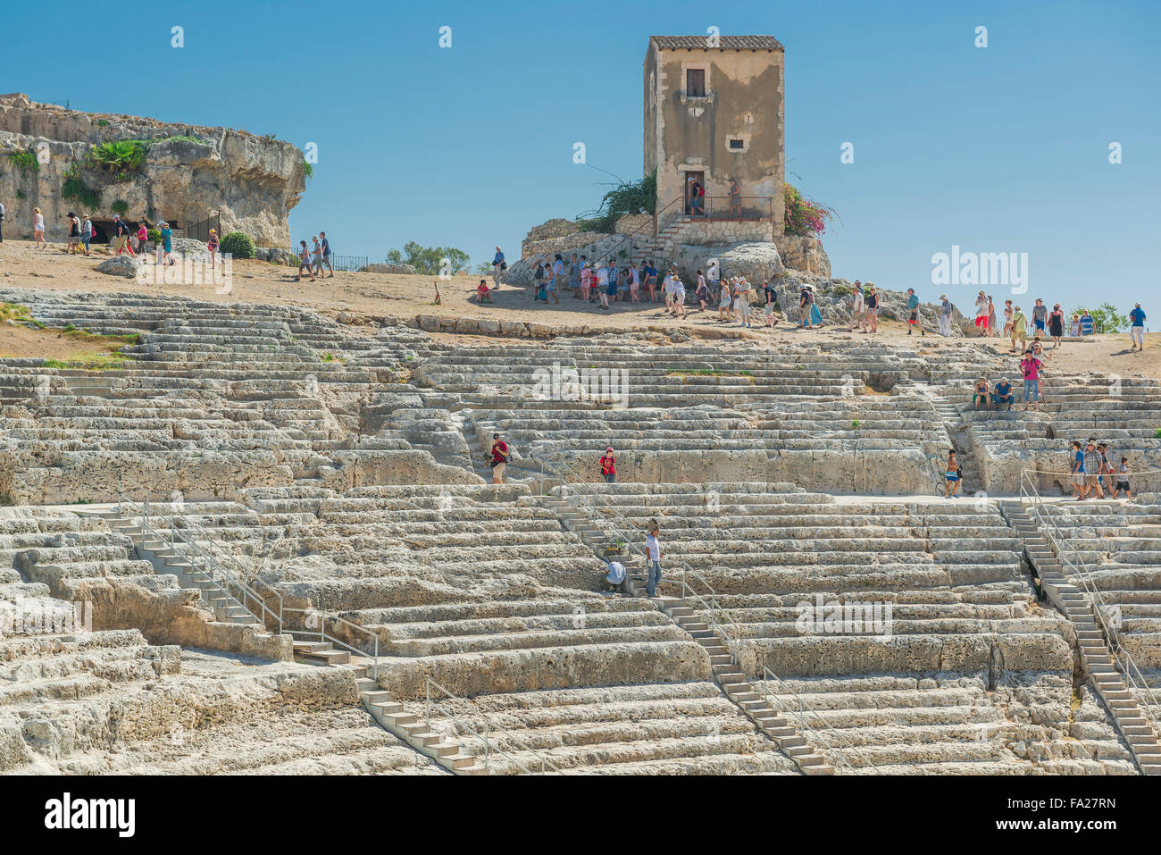 Sicily Greek theatre, view of tourists visiting the auditorium of the ancient Greek theater in the Archaeological Park at Syracuse (Siracusa), Sicily Stock Photo