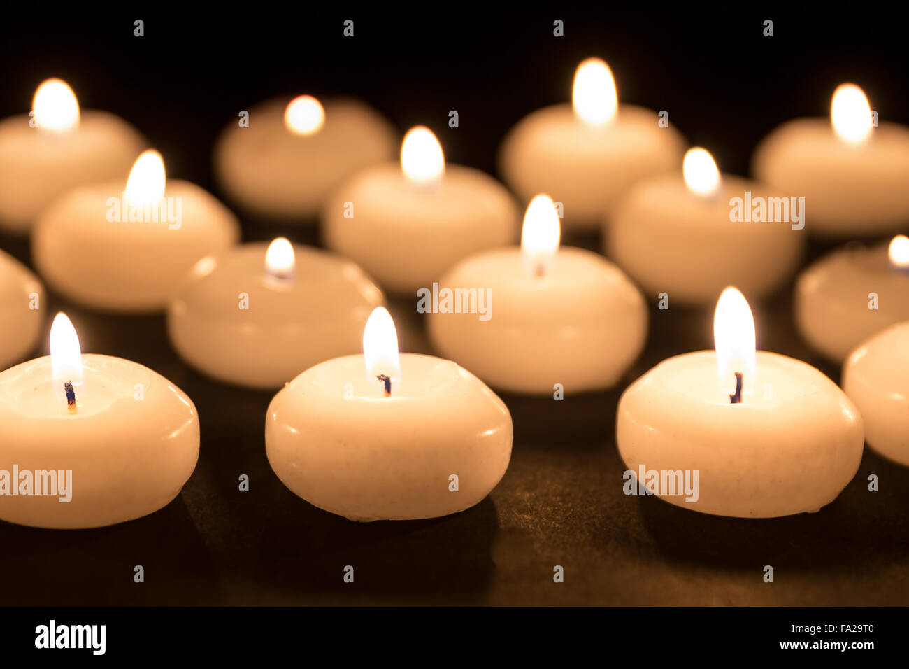 Group of burning candles at a black background Stock Photo - Alamy