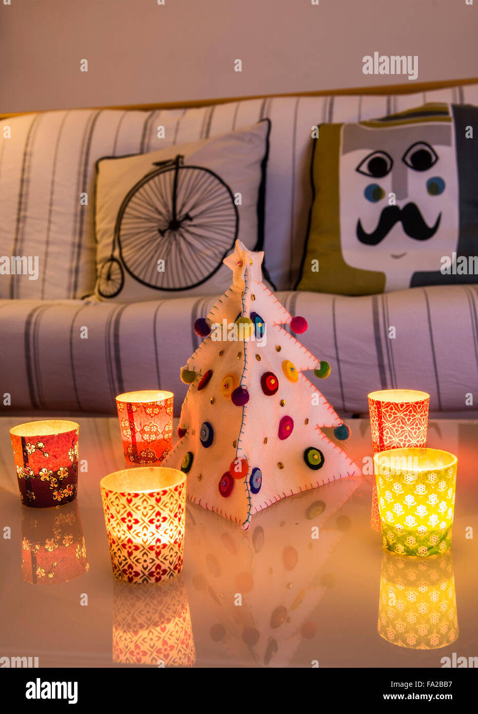 Italy, Chtistmas Atmosphere in stylish home. Small candles on the table and a Christmas tree made of cloth. Stock Photo