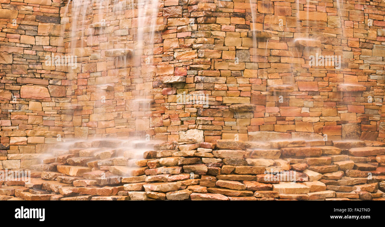 Water Cascading Over Stone Wall Stock Photo