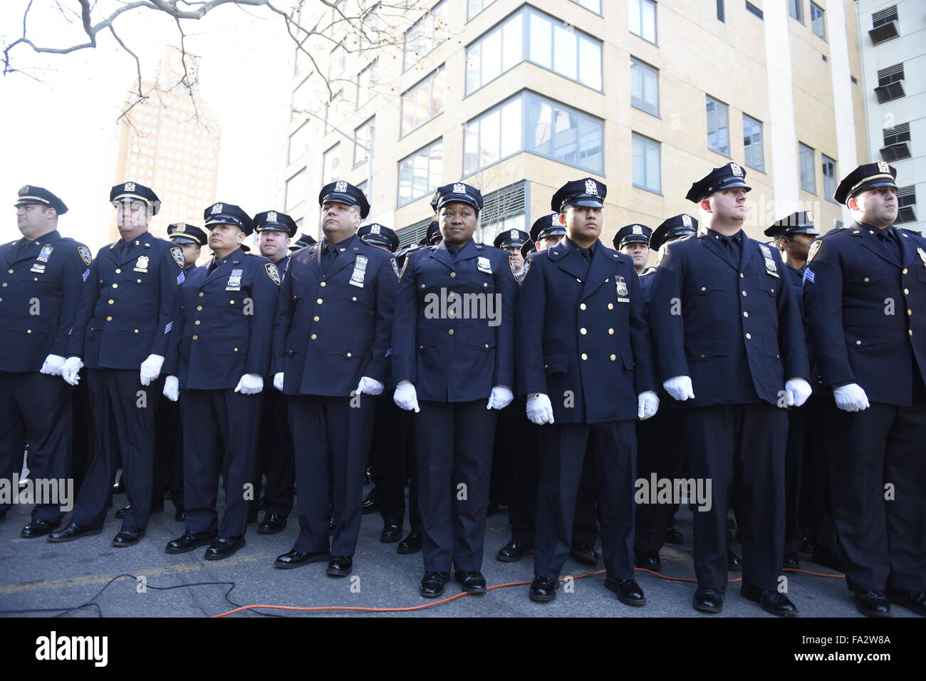 New York City, United States. 20th Dec, 2015. NYPD officers in dress uniform  stand at attention at 84th precinct. NYC mayor Bill de Blasio joined the  families of slain NYPD officers Wenjian