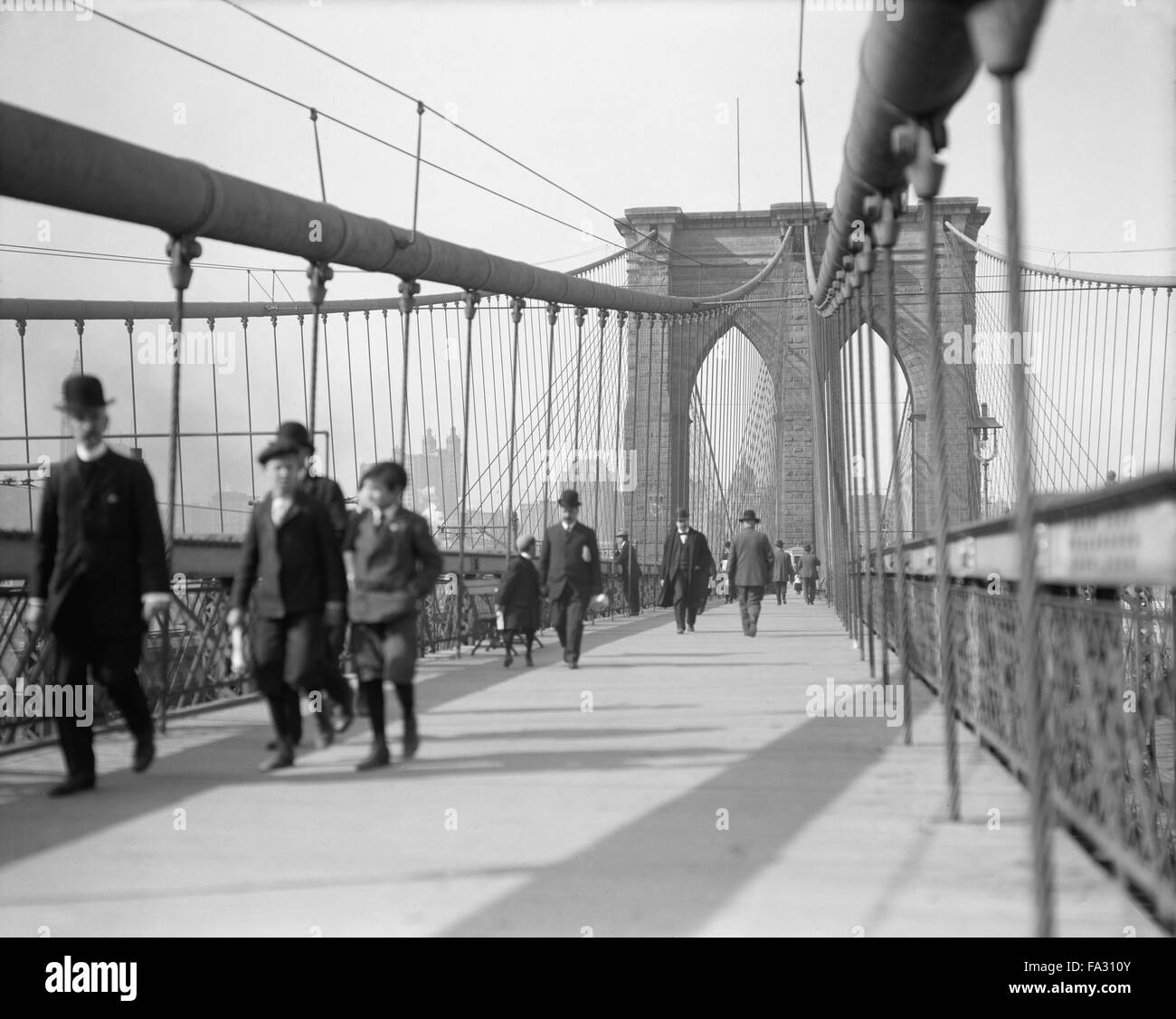 Pedestrians Walking Across Brooklyn Bridge, New York City, USA, circa 1910 Stock Photo