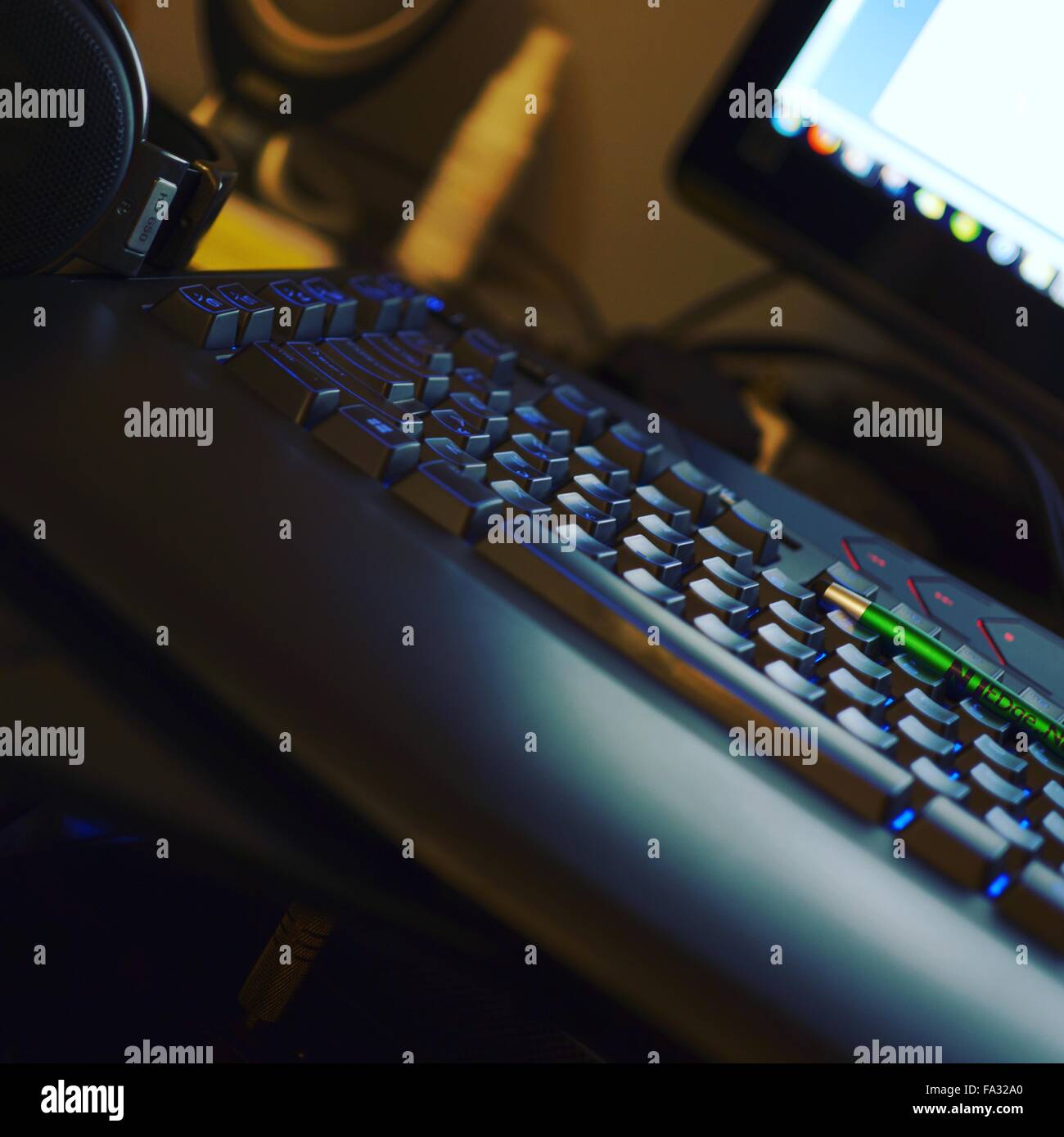 Blue light lit keyboard and headphones Stock Photo