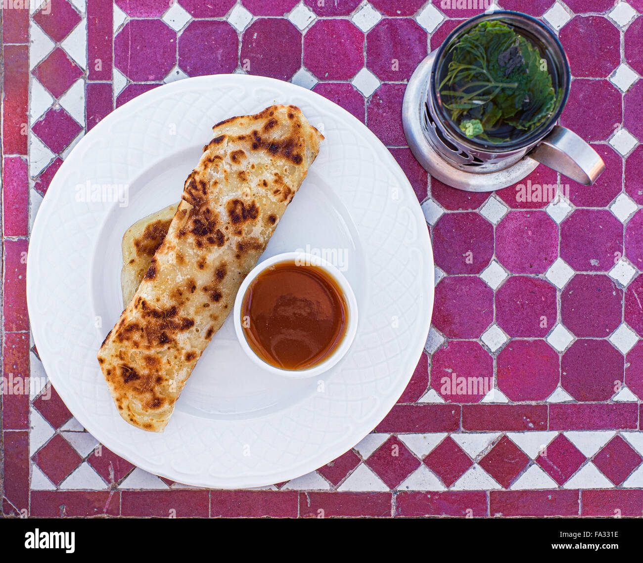 Msemen or Rghaif is a typical kitchen maghreb Berber flatbread. Typical moroccan breakfast, Msemen with honey and Moroccan tea Stock Photo