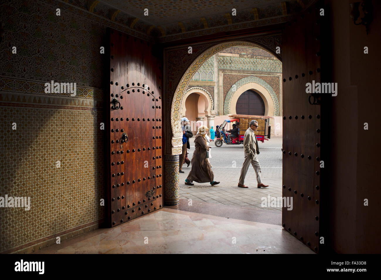 People walking in front of The Bab el Mansour gate, view from inside a entry hall of a classical building. Meknes. Morocco. Stock Photo