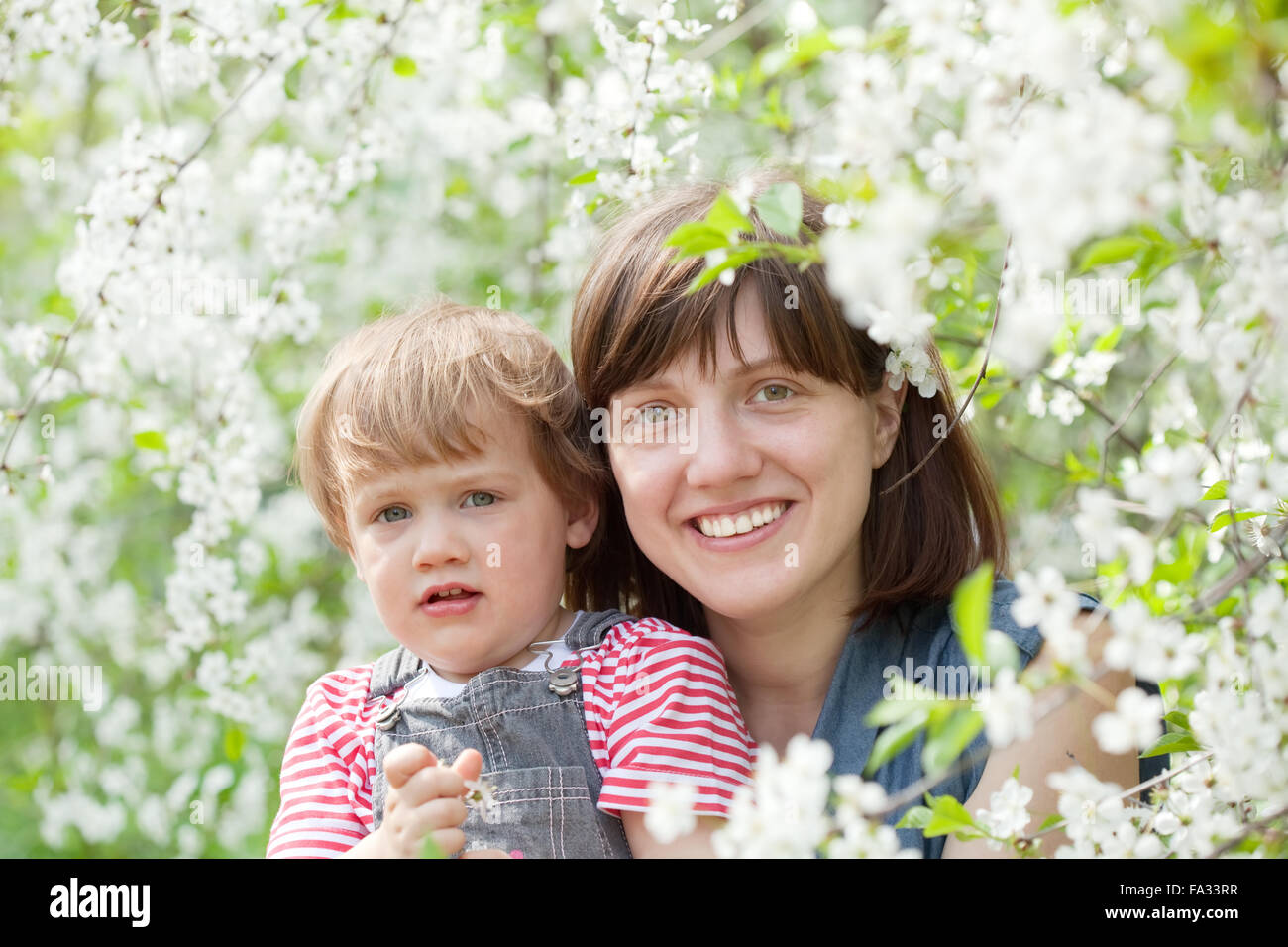 Happy family in spring blossoming garden Stock Photo - Alamy