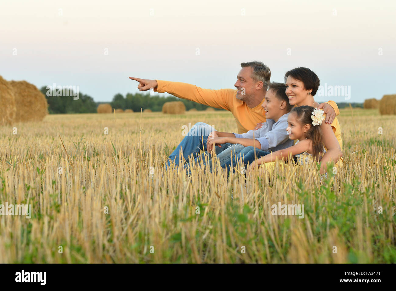 Happy family in wheat field Stock Photo - Alamy