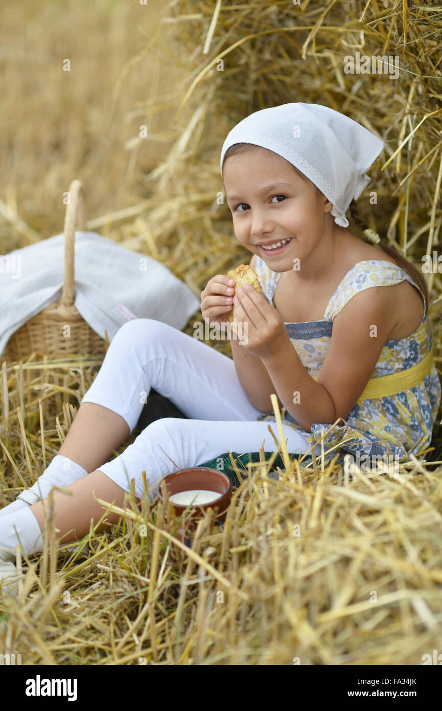 Girl with milk and fritter in field Stock Photo
