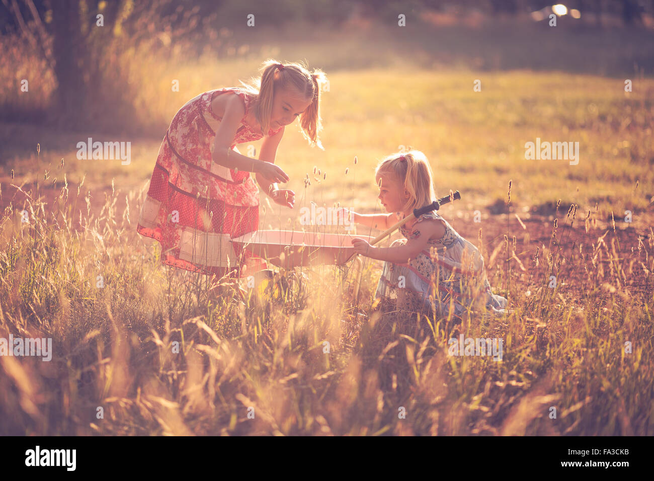 Two little sisters enjoying playing in nature Stock Photo