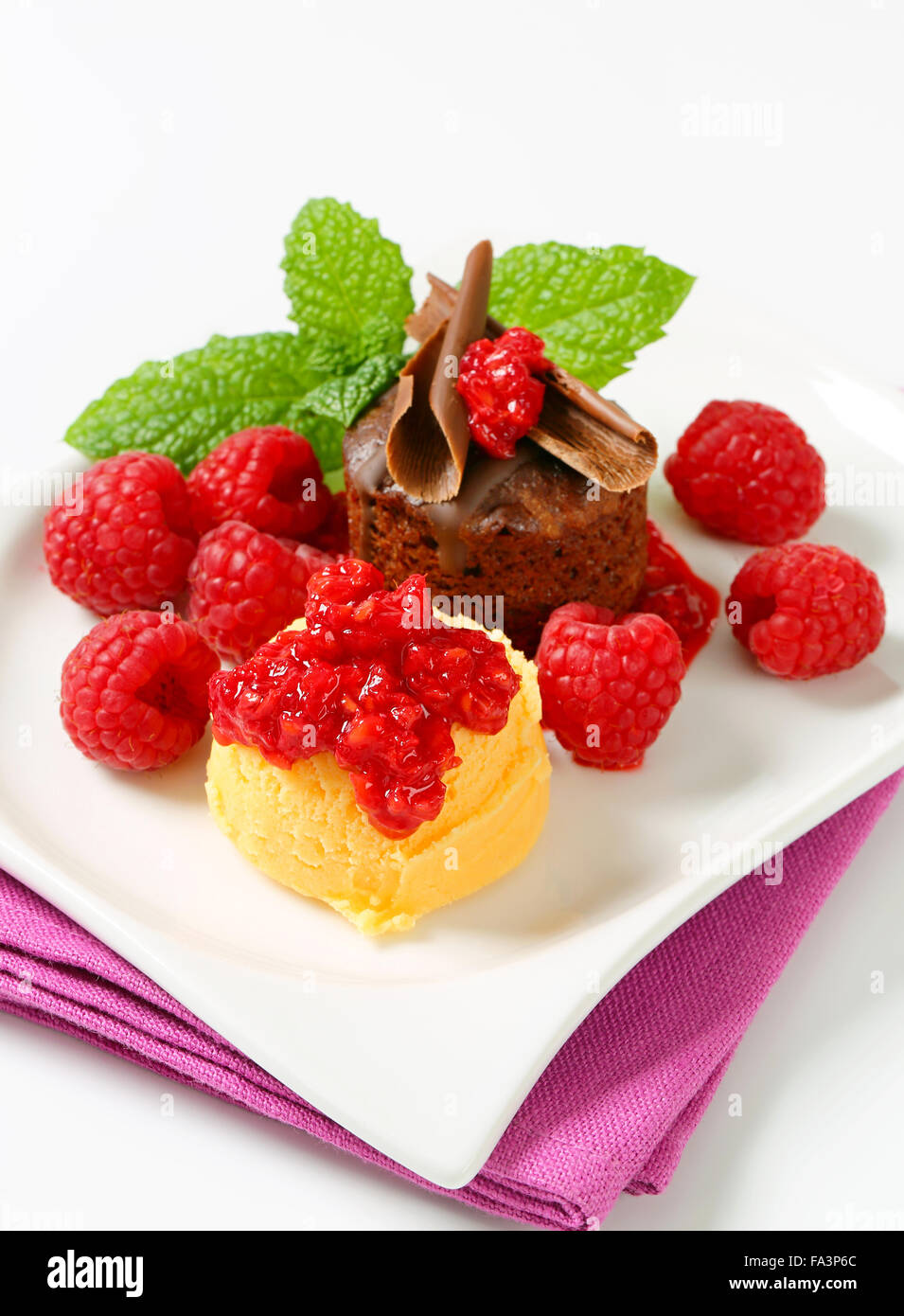 Mini chocolate cake served with fresh raspberries and scoop of ice ...