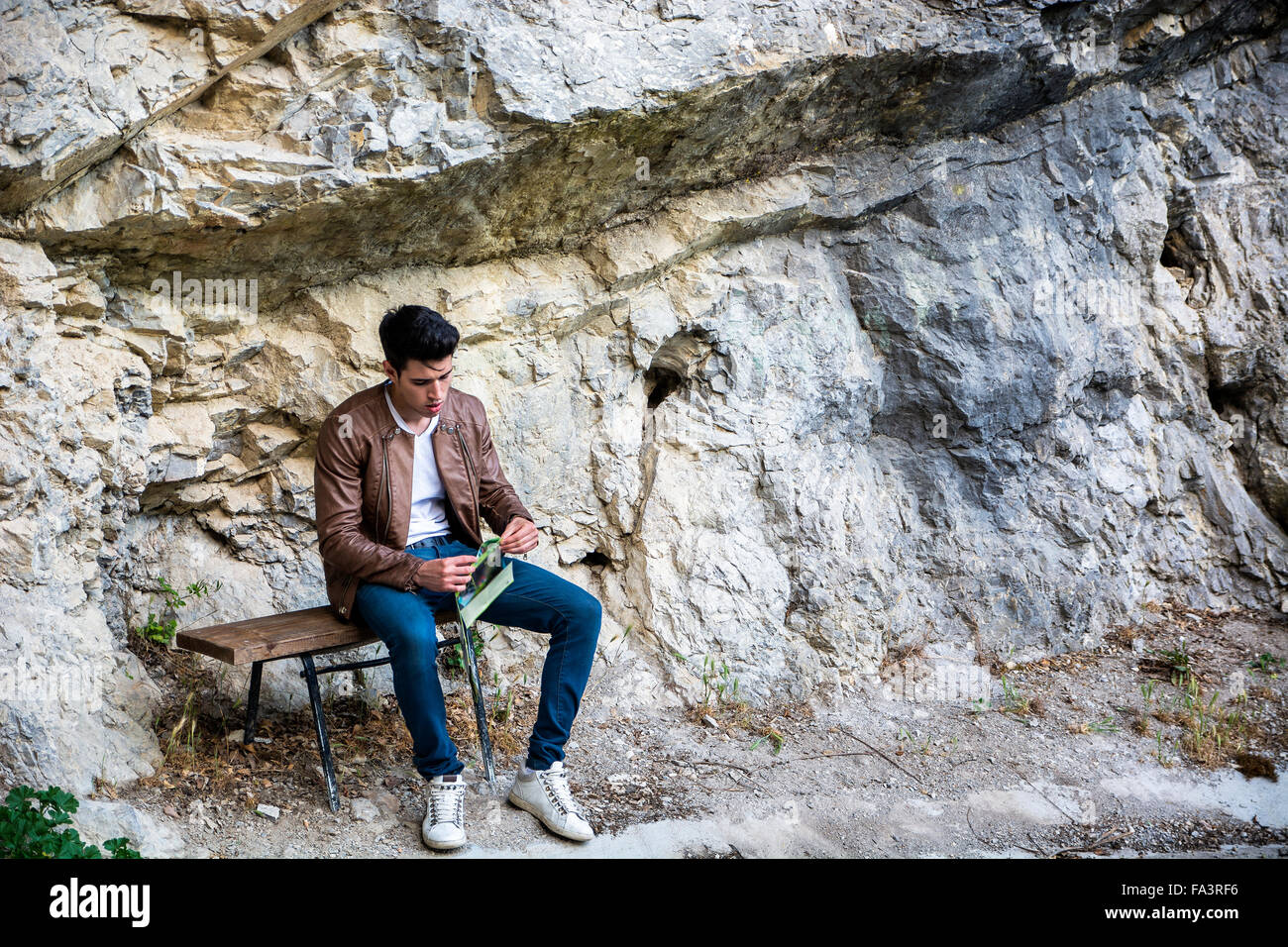 Handsome young man sitting in natural park, looking away Stock Photo ...