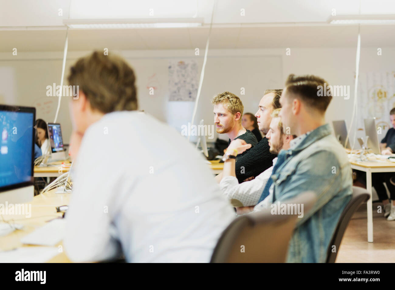 Media students using computer at table in classroom Stock Photo - Alamy