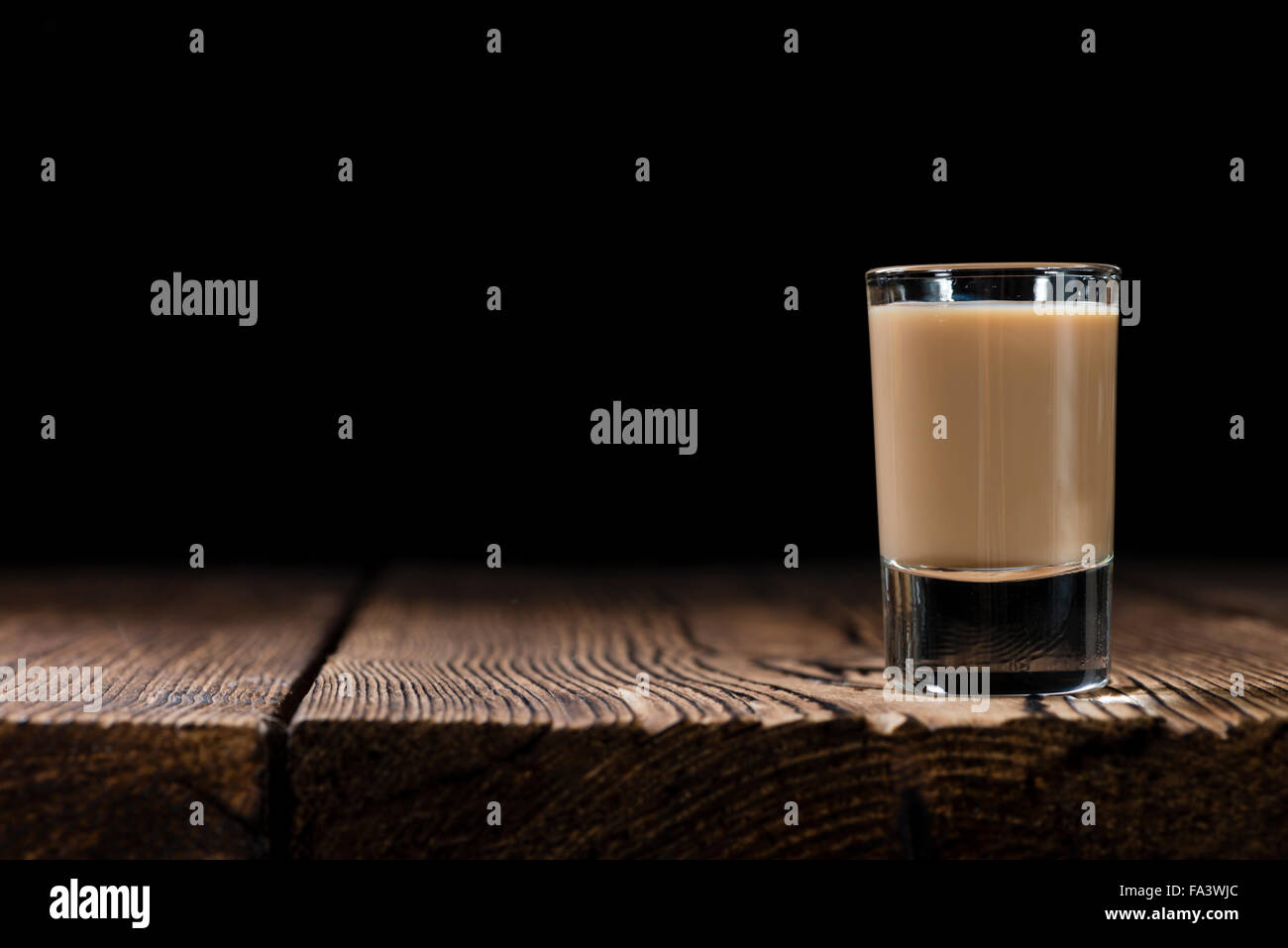 Irish Cream Liqueur (detailed close-up shot) on wooden background Stock Photo
