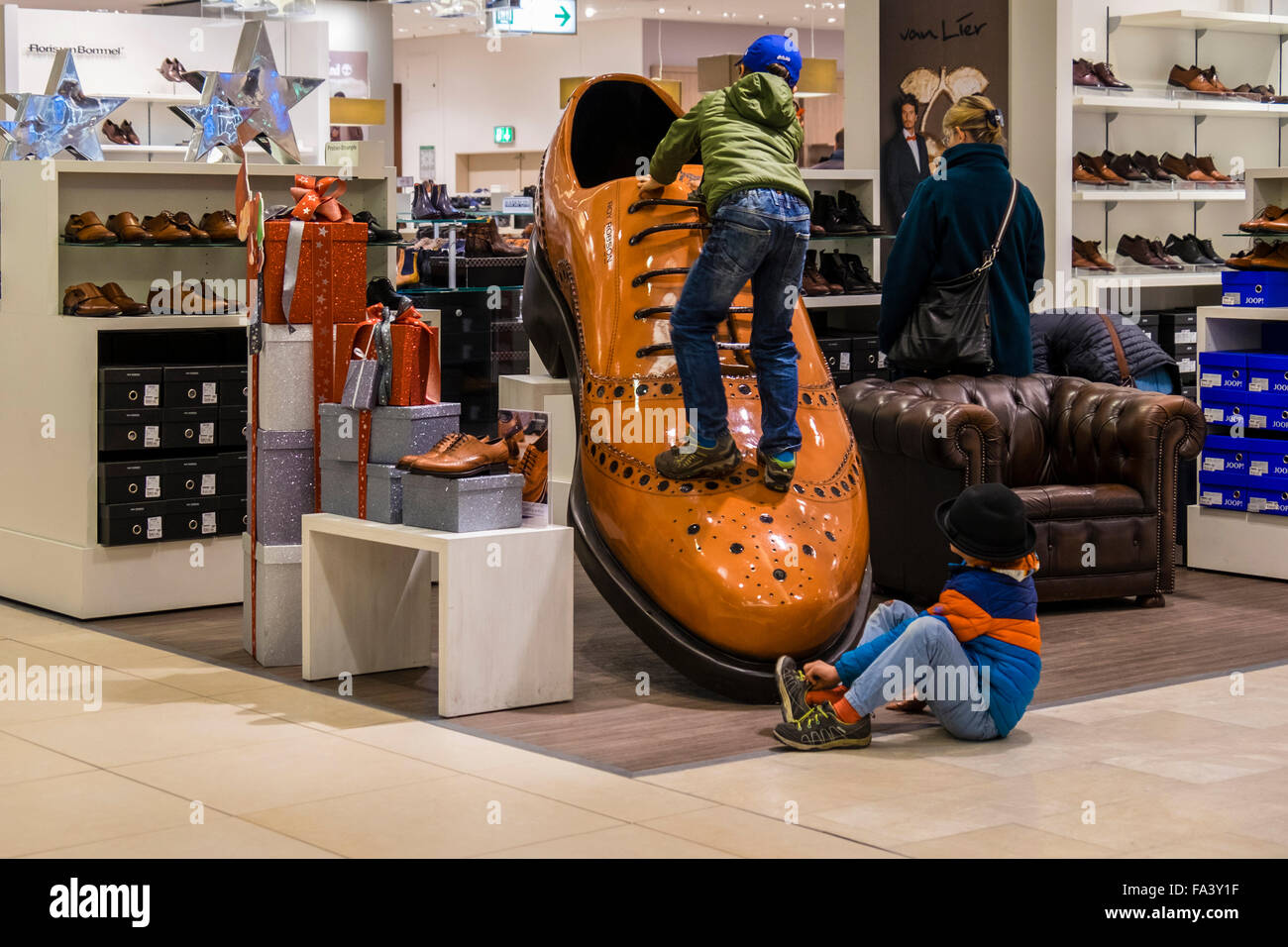 Two young boys play on giant shoe of display in Galeria Kaufhof Department  Store Berlin, Germany Stock Photo - Alamy