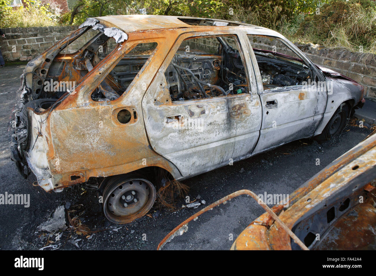 Remains of a burnt out car in a car park Stock Photo - Alamy