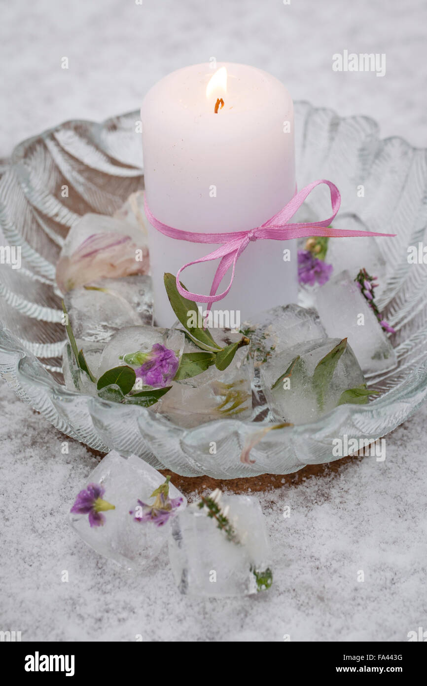 Material: mold for ice, water, heather flower, small flowers, bowl, candle,  ribbon. Procedure: Put small flowers in ice cube molds. Pour water into the  ice cube molds. Give everything frozen. Candle decorations