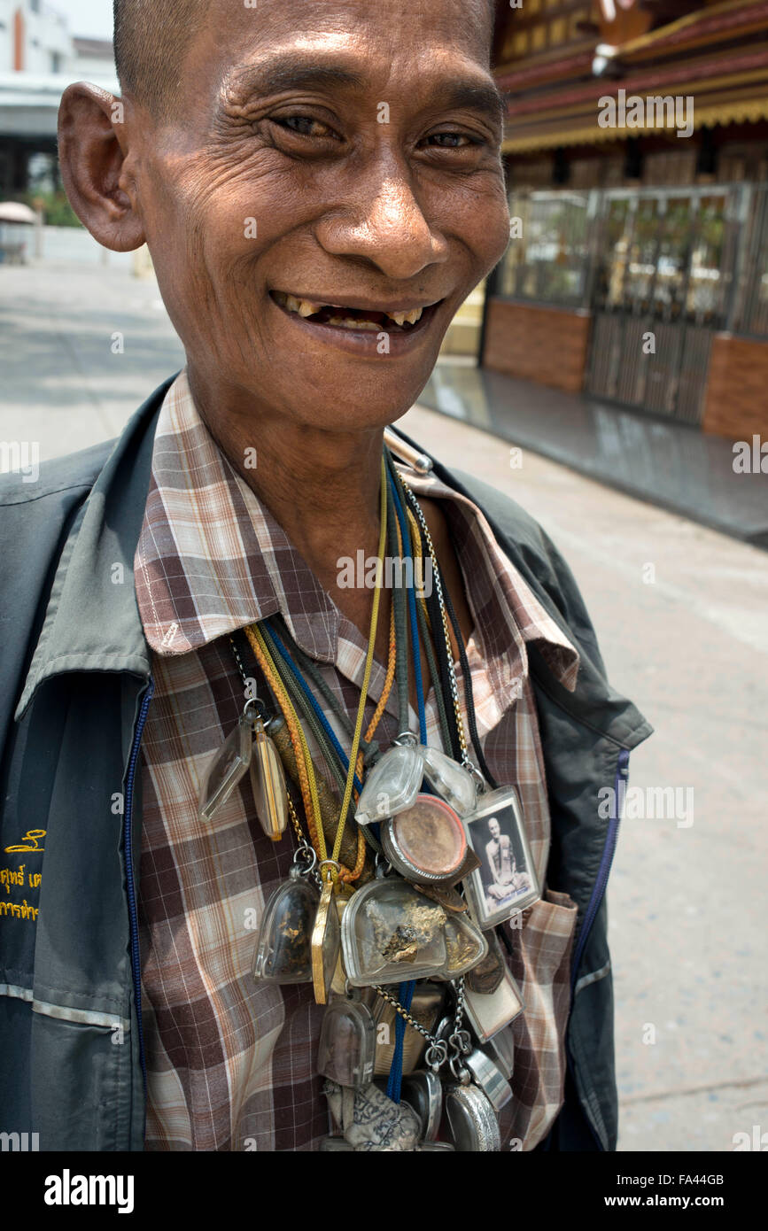 Man loaded down with good luck amulets in Bangkok Thailand. Amulets at