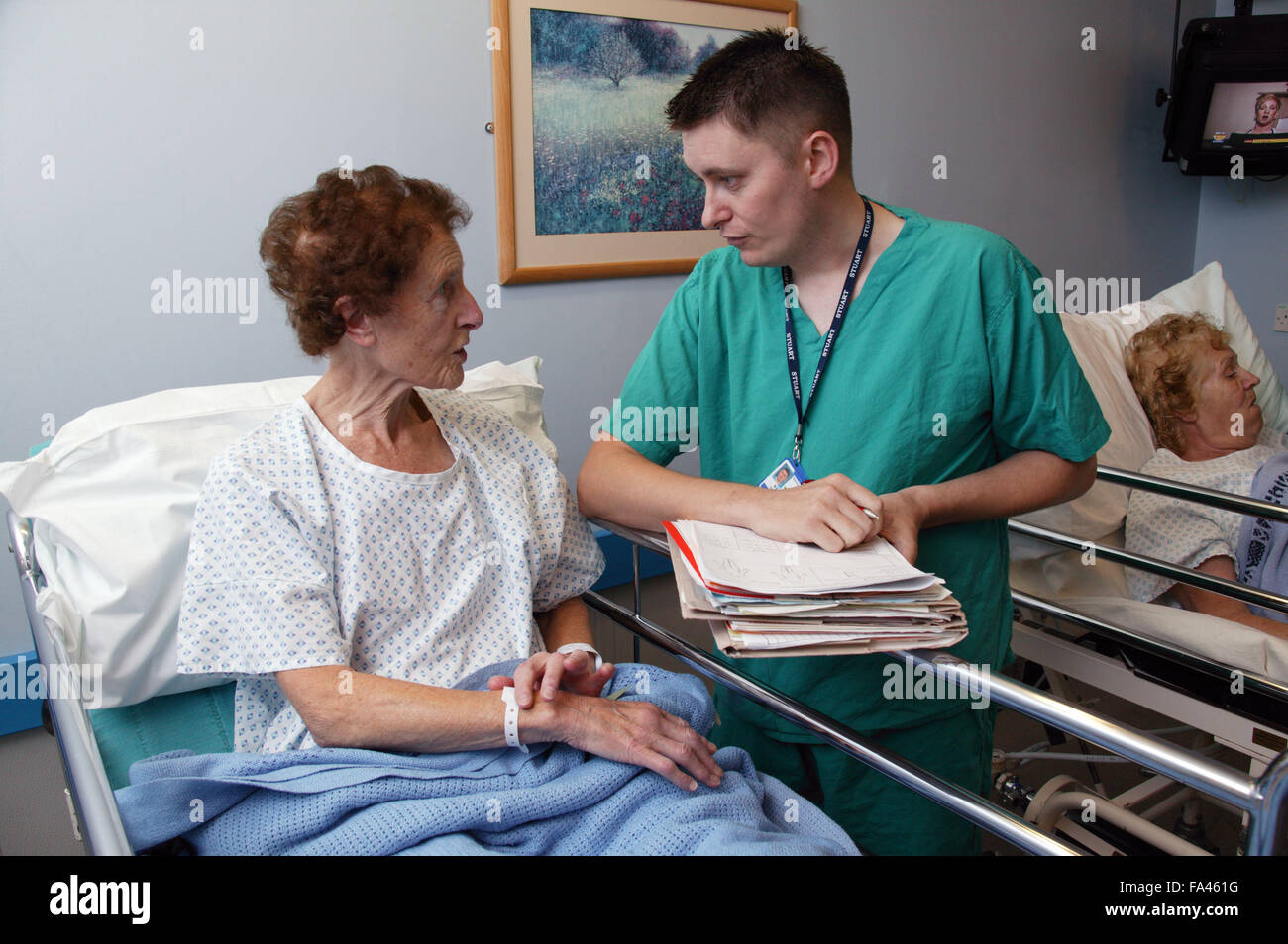 Theatre Support Worker in discussion with patient prior to undergoing a hip operation, Stock Photo