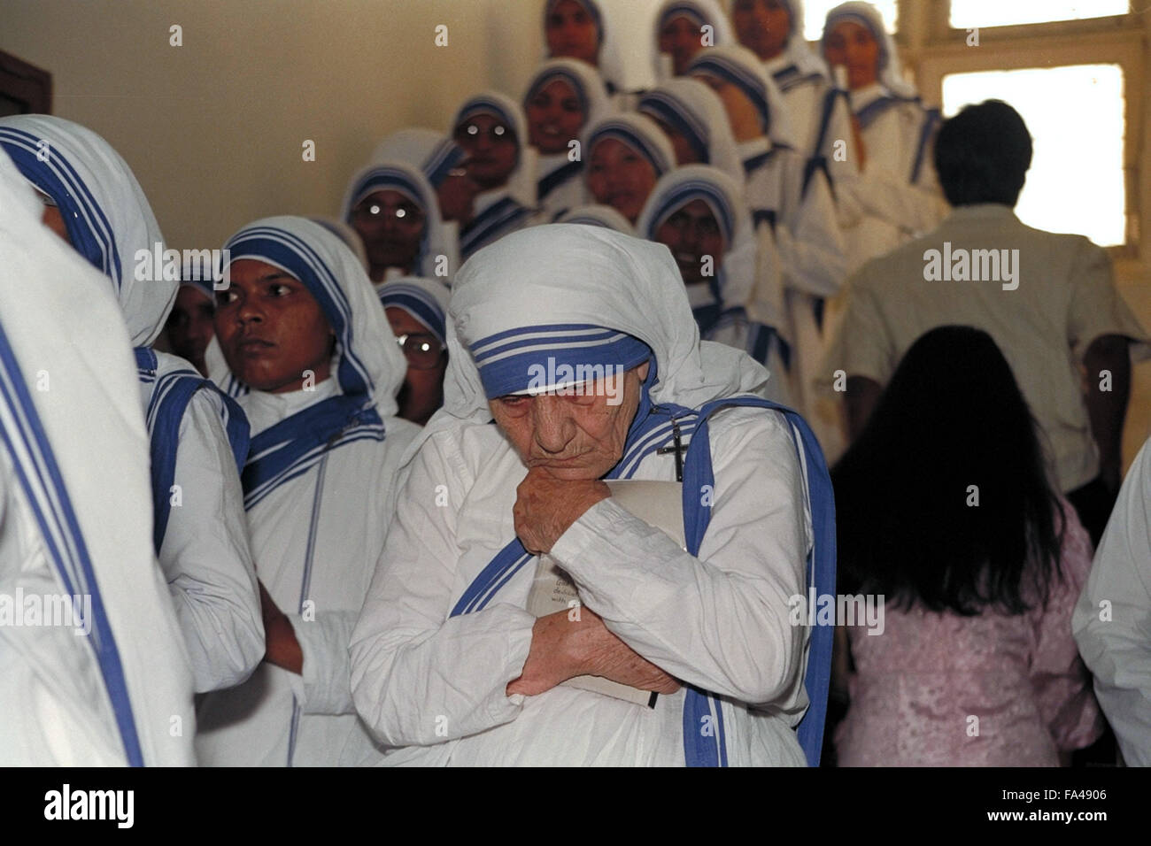 Mother Teresa leaning forward deep in thought moment before her sisters of the Missionaries of Charity take their final vows to the order she founded in 1950. This was on the stairwell of St. Mary's Catholic Church in Kolkata, India. It was also the last time Mother Teresa was present during the procession of vows ceremony. Stock Photo