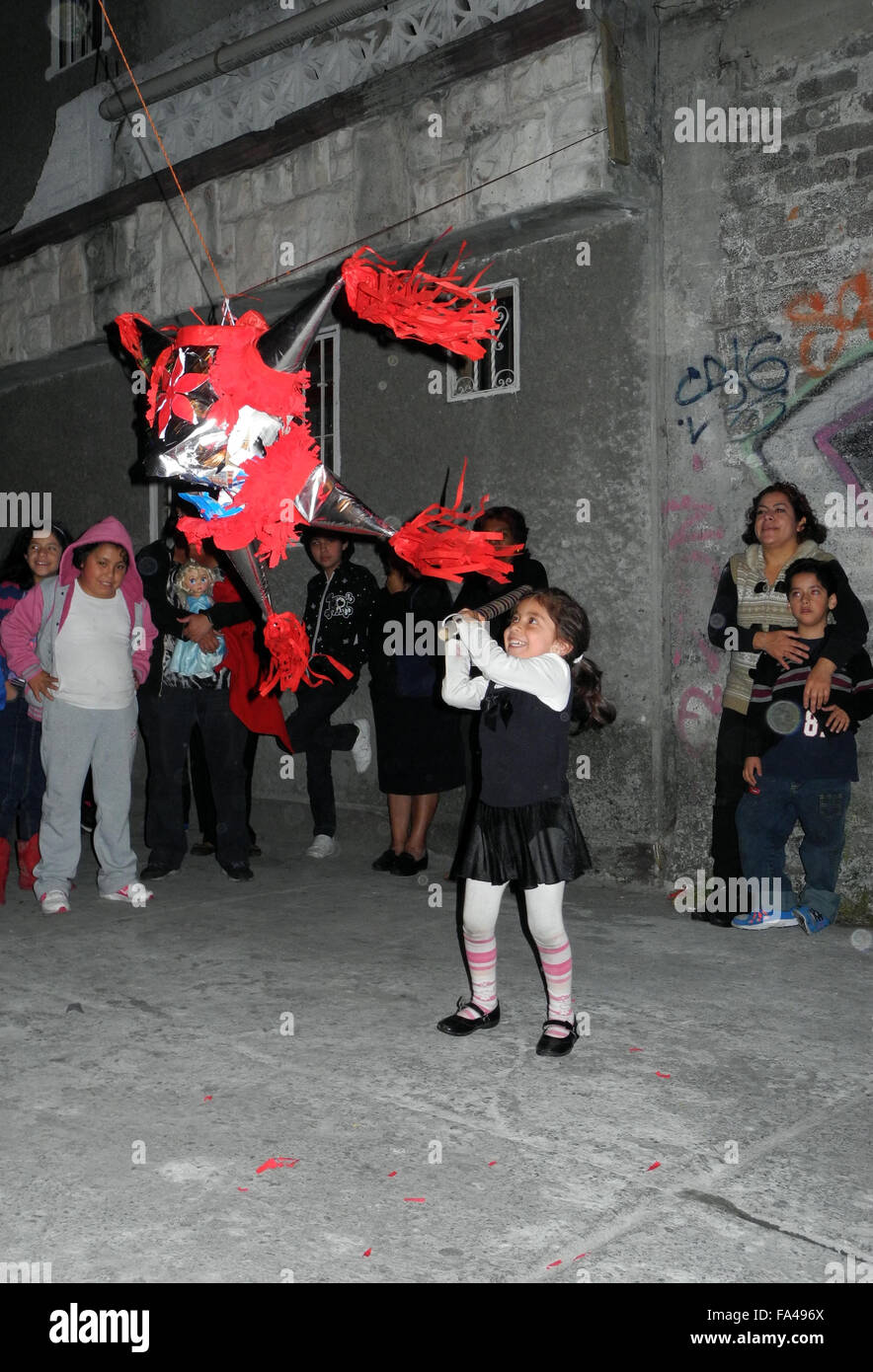 Mexico City, Mexico. 22nd Dec, 2014. Children hitting a pinata in the  Iztacalco district of Mexico City, Mexico, 22 December 2014. The cardboard  pinatas are filled with sweets. When they burst after