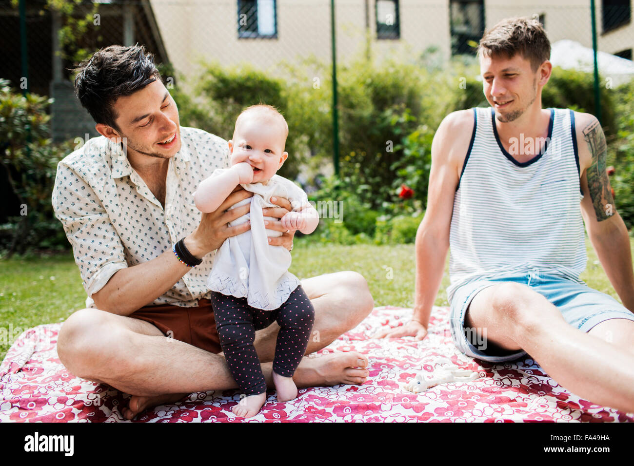 Portrait Of Cute Baby Girl With Gay Couple At Yard Portrait Of Cute Baby Girl With Gay Couple At Yard