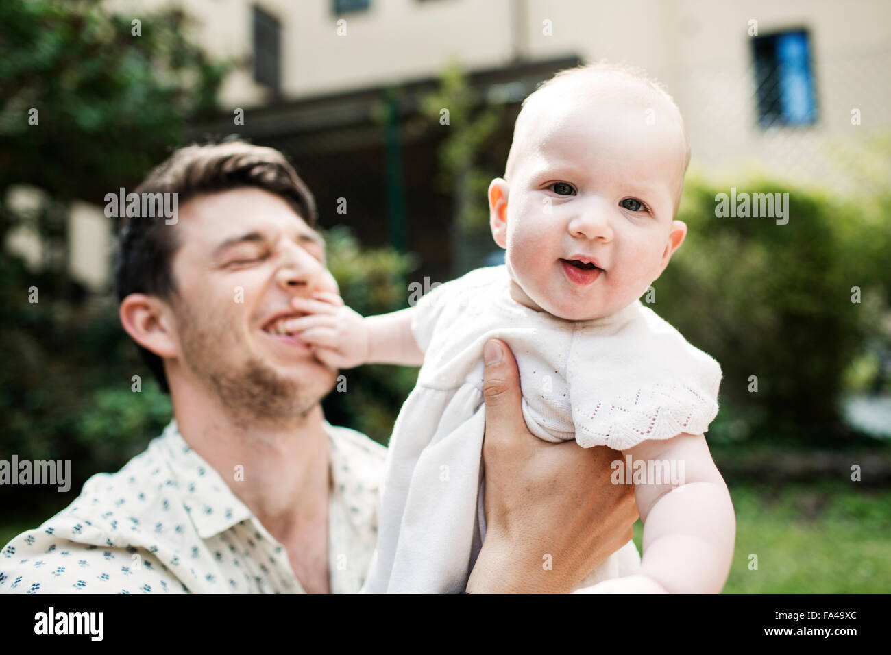 Portrait of cute baby girl being carried by father at yard Stock Photo