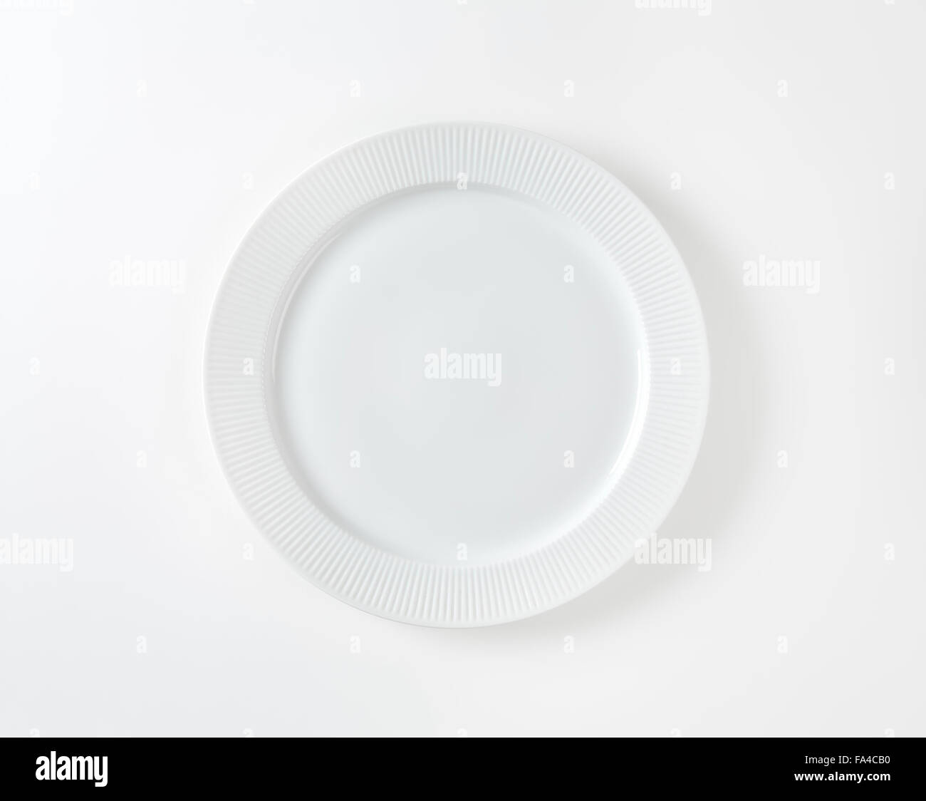 white plate with fluted rim on white background Stock Photo Alamy