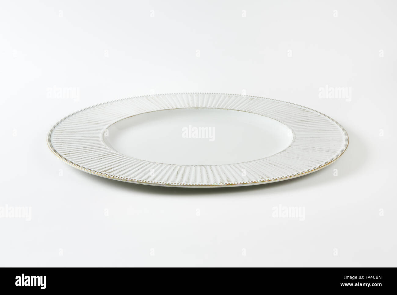 white plate with gold fluted rim on white background Stock Photo Alamy
