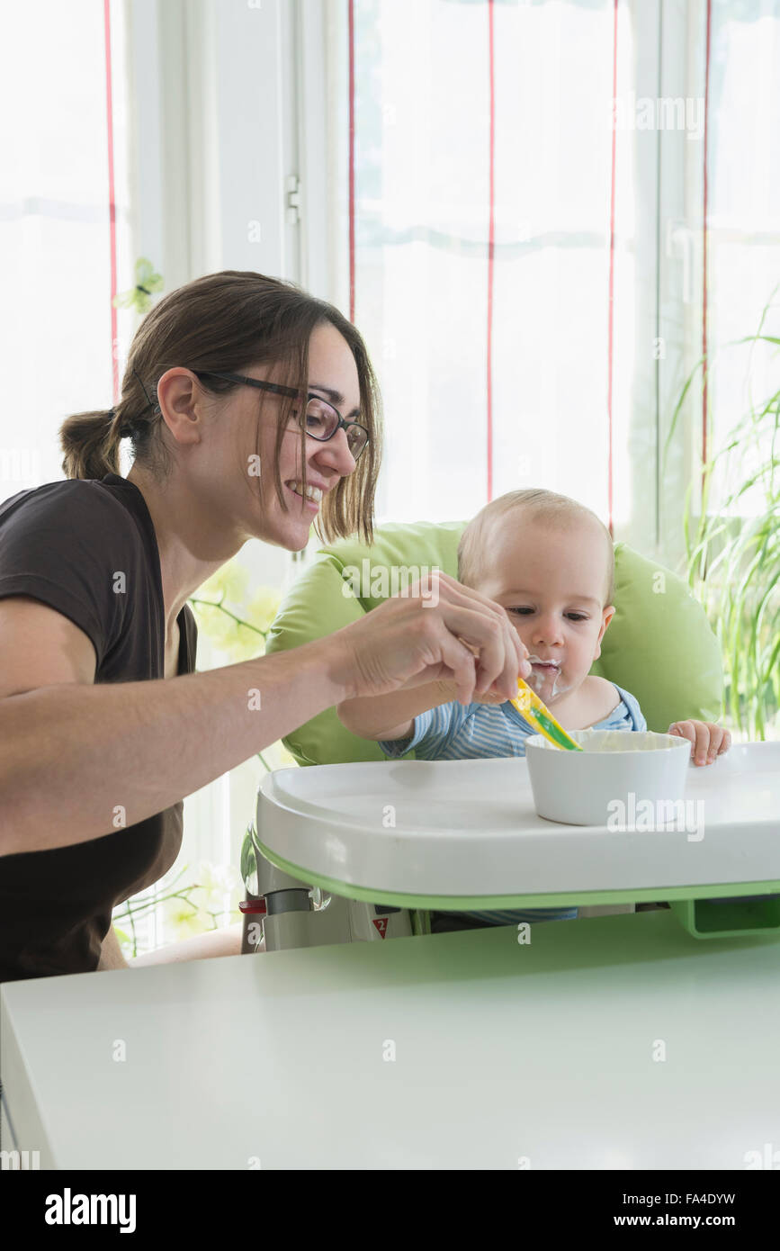 Mother feeding baby food to her baby boy with spoon, Munich, Bavaria, Germany Stock Photo