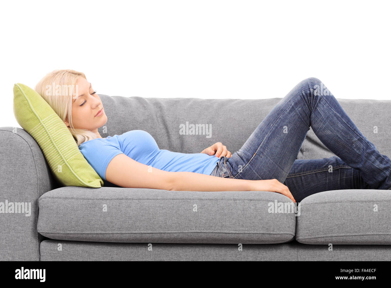Young blond woman sleeping on a gray couch isolated on white background Stock Photo