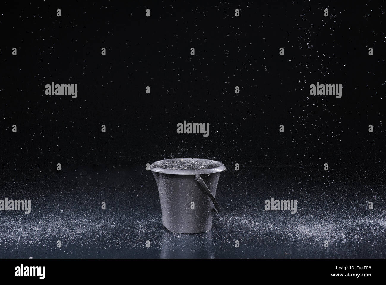 Bucket with water drops on dark background Stock Photo - Alamy