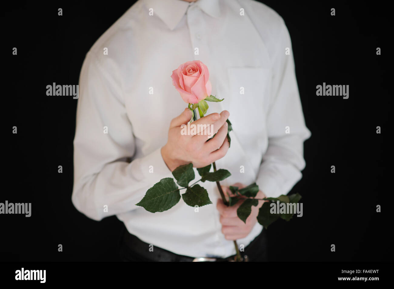 man holding rose on black background close-up Stock Photo