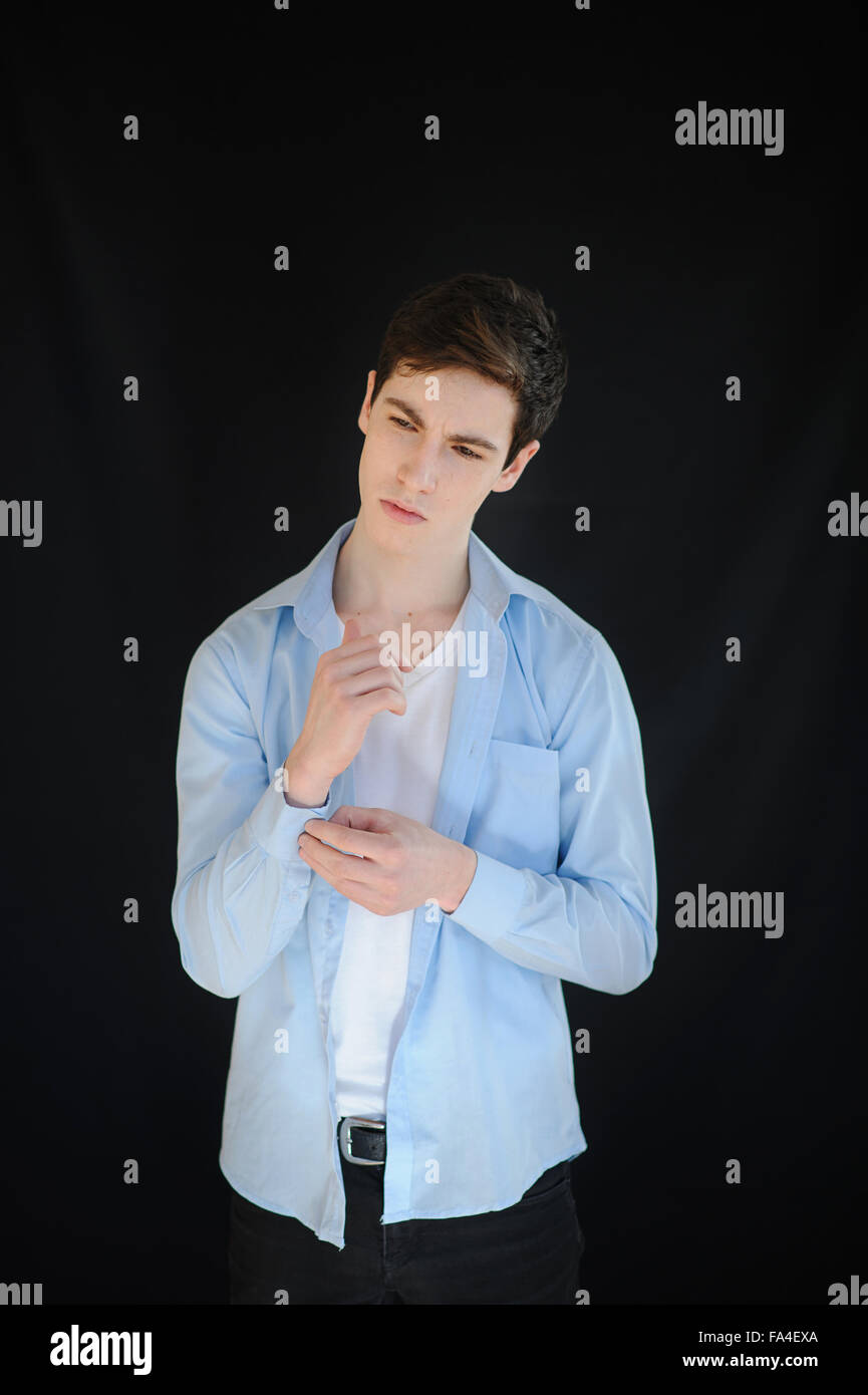 Young Man Buttoning His Shirt On Black Background Stock Photo Alamy