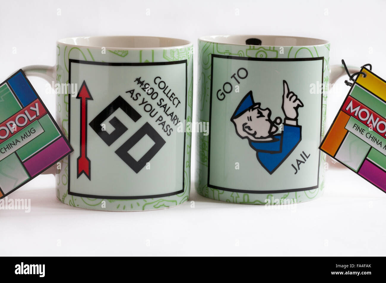 Monopoly fine china mugs with label tag - Go to jail and collect 200 salary as you pass go set on white background Stock Photo
