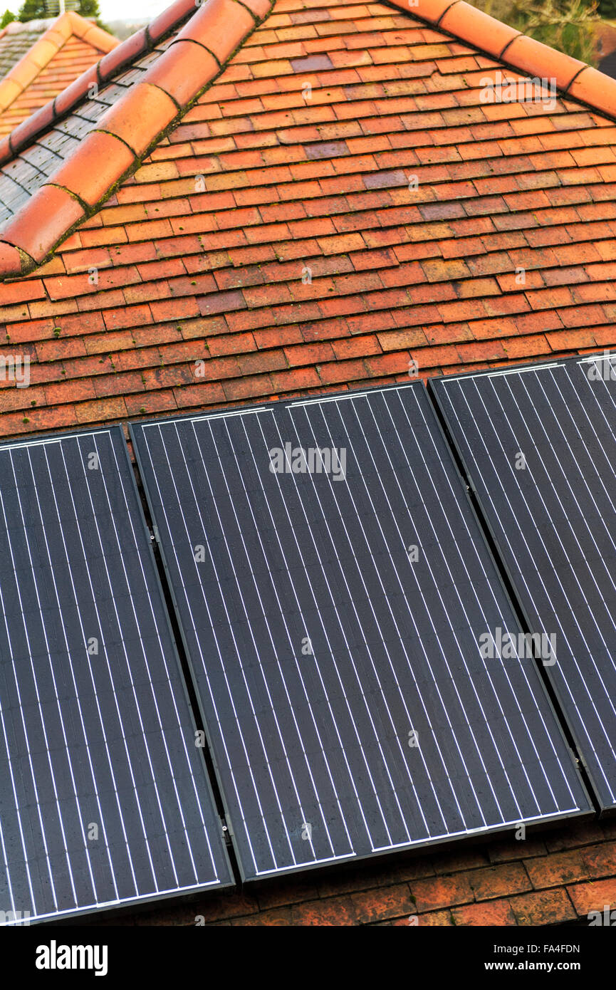 Solar roof panels on the roof of an urban bungalow. Stock Photo