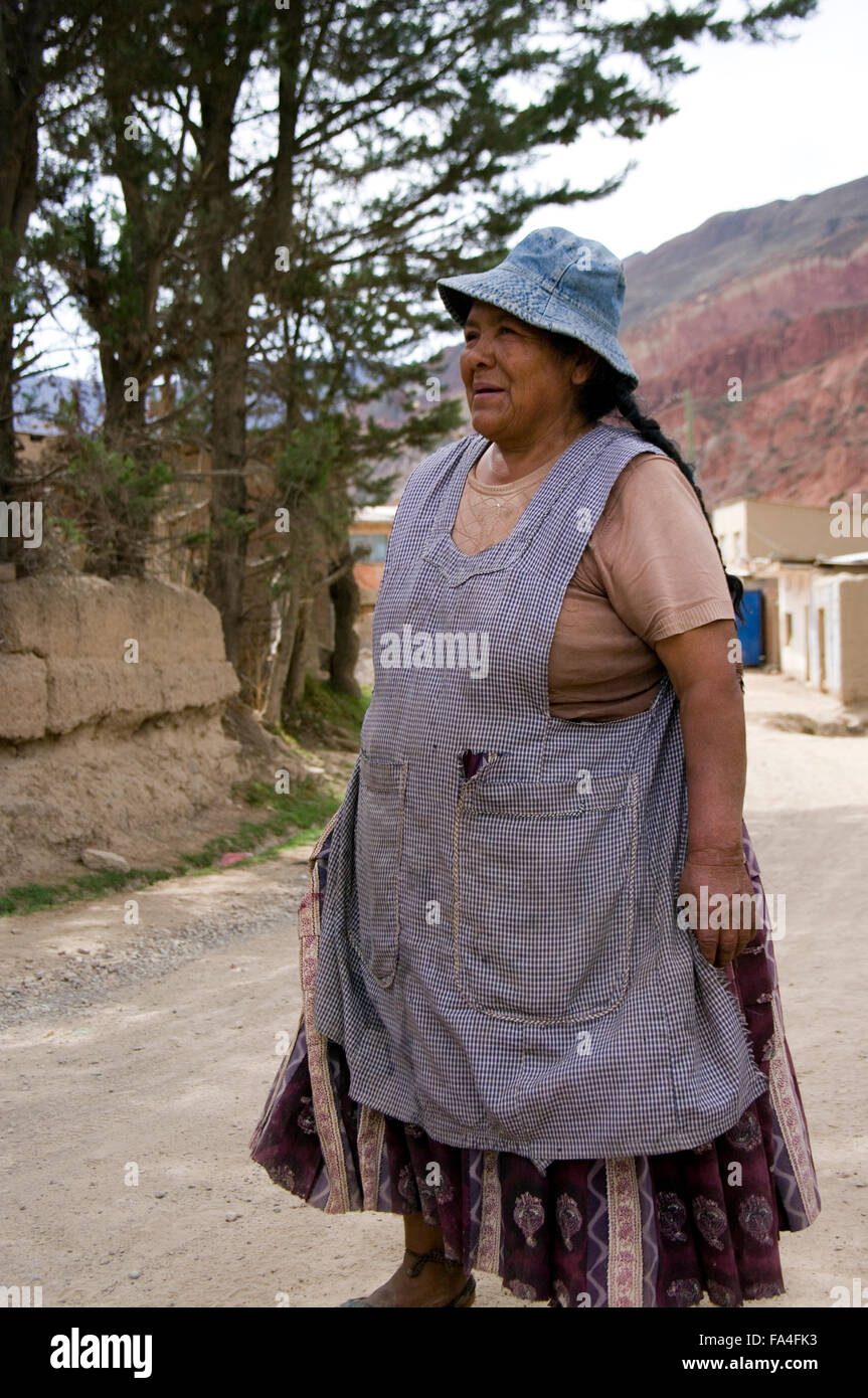Portrait of a strong, elderly Bolivian woman standing on a dirt road in a village in Bolivia wearing a blue hat, apron and dress Stock Photo